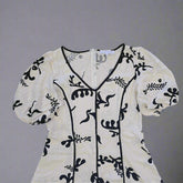 White garment with black floral patterns on a tiled floor